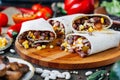 Nice vegetarian burrito over black table on wooden board. Royalty Free Stock Photo