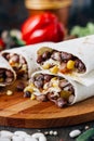 Nice vegetarian burrito over black table on wooden board. Royalty Free Stock Photo