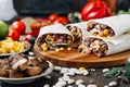 Nice vegetarian burrito over black table on wooden board. Royalty Free Stock Photo