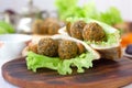 Nice vegetarian falafel in pita bread on wooden board.