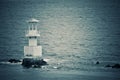 Nice view of the lighthouse in the sea, vintage photo style. Royalty Free Stock Photo