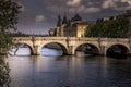 Nice view of Pont Neuf bridge and Conciergerie in background on a stormy end of the day in Paris Royalty Free Stock Photo