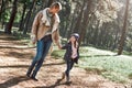 Nice walk with mom. A little curly girl is walking with her mother in forest