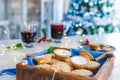 Nice warm cosy composition of traditional english festive pastry mince pies in wooden tray with mulled wine drinks and lights