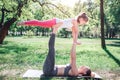 Nice and warm picture of woman holding her child on feet. Small girl is keeping her hands on mom`s hands and kepping her