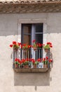 Nice windows with geranium flowers in a spanish town Gerona. Royalty Free Stock Photo