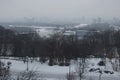 Nice winter landscape. Morning in city. Children`s playground in the park. Buildings are hiding in the fog on the left bank of the Royalty Free Stock Photo