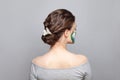 Nice woman back and head with perfect updo hairdo and painted flowers on her skin on gray background Royalty Free Stock Photo