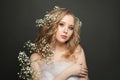 Nice woman with long healthy curly hair and white flowers. Attractive spring on dark background