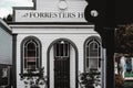 nice wooden entrance of forresters hall with round windows in quiet lonely quiet village under cloudy sky, west