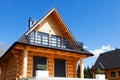 Nice wooden house with a balcony, on a hill under a blue sky