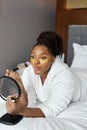 Beautiful young African woman with gold eye mask, medical eye antiwrinkle patches and doing natural nude make-up Royalty Free Stock Photo