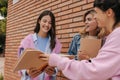 Nice young caucasian girls with notebooks spend time together after class outside. Royalty Free Stock Photo