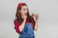 Nice young girl holding big doughnut, looking at it as if ready to eat it at once.