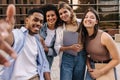 Nice young interracial students taking selfie relaxing at recess near college during day.