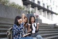 Nice young students use laptop after class sitting outdoors. girls wear casual clothes in spring. Concept of modern Royalty Free Stock Photo