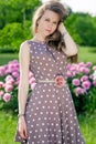 Nice young woman in the park near peonies Royalty Free Stock Photo