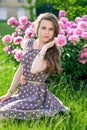 Nice young woman in the park near peonies Royalty Free Stock Photo
