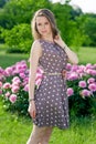 Nice young woman in the park near peonies Royalty Free Stock Photo