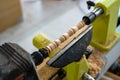 The nicely decorated detail set in spinning machine at workshop. Joiner is making wooden fretwork stick.