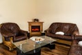 Nicely furnished sitting room with brown sofas and a glass table inside of a modern house