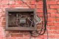 Niche of an old broken electrical panel on the background of an old red brick wall texture Royalty Free Stock Photo