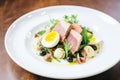 nicoise salad with tuna, eggs, and olives on a white plate