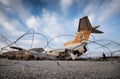 Abandoned destroyed airplane and metal border fence