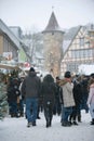 Schimmelturm Rising above Traditional Christmas Market. People on the Street, Christmas Trees and Kiosks, Falling snow.