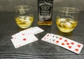 A game of poker and a glass of whiskey with ice.