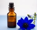 Nigella blue flower and essential oil in a glass bottle on white background Royalty Free Stock Photo