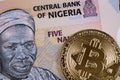 Nigerian five Naira bank note with a golden bitcoin