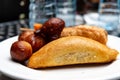 Nigerian meat pie, puff-puff, fish roll and stick meat gizzard pastries or Nigerian small chops in white saucer for Nigerian break