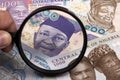 Nigerian money in a magnifying glass