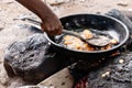 Nigerian Woman stirring Akara Fried Bean Cake on fire in hot oil