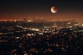 Night aerial view of city lights surrounded by buildings with a full moon in Los Angeles, USA