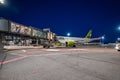 Night airport with many airplanes by the runway.