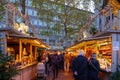 Night atmosphere with crowd of people and illuminated decorated stalls at Christmas Market.