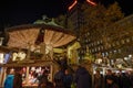 Night atmosphere with crowd of people and illuminated decorated stalls at Christmas Market.