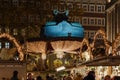 Night atmosphere with crowd of people and illuminated decorated stalls at Christmas Market.