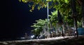 Night beach with folded umbrellas in a row. Sunshades in the dark Royalty Free Stock Photo