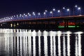 The night bridge with beautiful lanterns is reflected in the water on the Dnieper River, in the Dnepropetrovsk city Royalty Free Stock Photo