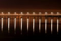 The night bridge with beautiful lanterns is reflected in the water on the River. Evening river landscape in a big city Royalty Free Stock Photo