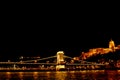 Night Budapest, glowing in gold. The chain bridge over the Danube is illuminated by light bulbs. photo from the river Royalty Free Stock Photo