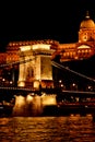 Night Budapest, glowing in gold. The chain bridge over the Danube is illuminated by light bulbs. photo from the river Royalty Free Stock Photo