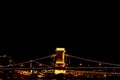 Night Budapest, glowing in gold. The chain bridge over the Danube is illuminated by light bulbs. photo from the river Royalty Free Stock Photo