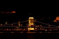 Night Budapest, glowing in gold. The chain bridge over the Danube is illuminated by light bulbs. photo from the river Royalty Free Stock Photo