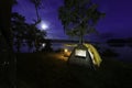 Night camping adventure with a cozy tent lit under the starry sky in a summer forest Royalty Free Stock Photo