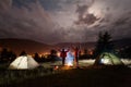 Night camping. Couple stands holding hands lifting up