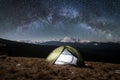 Night camping. Illuminated tourist tent under beautiful night sky full of stars and milky way Royalty Free Stock Photo